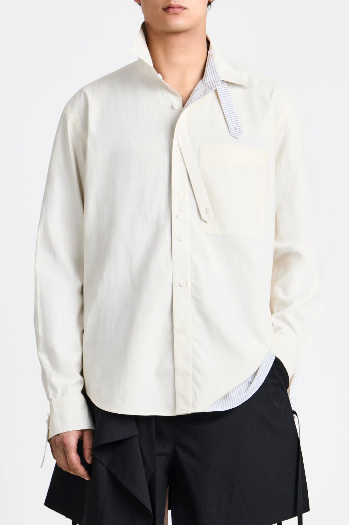 Front view of a model wearing the ecru side of the Craig Green reversible shirt featuring the patch pocket details.